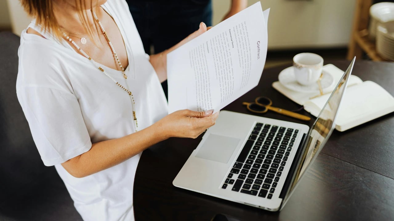 Imagem mostra uma pessoa mexendo em conrato com um notebook em frente. Em uma honding familiar, 
<p>normalmente, o patriarca ou matriarca da família são designados como administradores da sociedade" /><figcaption>Crédito: Canva</figcaption></figure></p>
<h2 id=