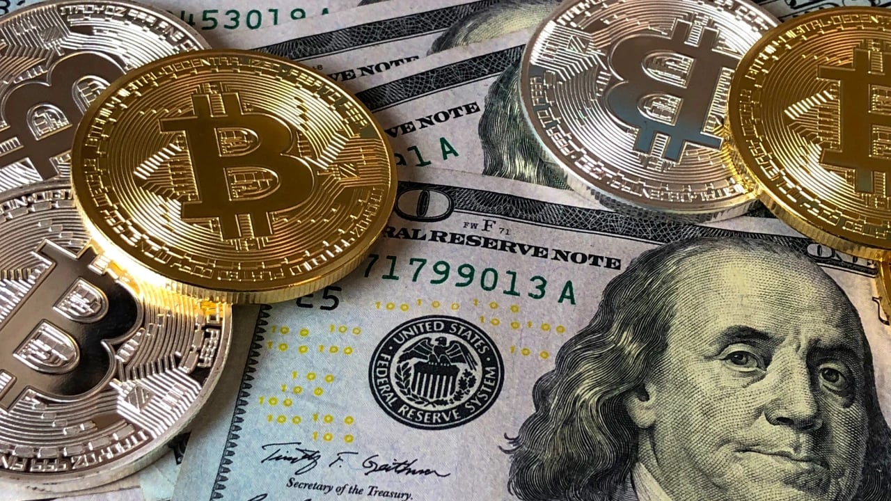 Imagem mostra bitcoin e dólar