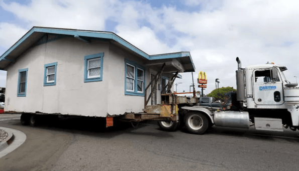 Casa residencial sendo transportada em um caminhão nos Estados Unidos, prática comum no mercado imobiliário americano