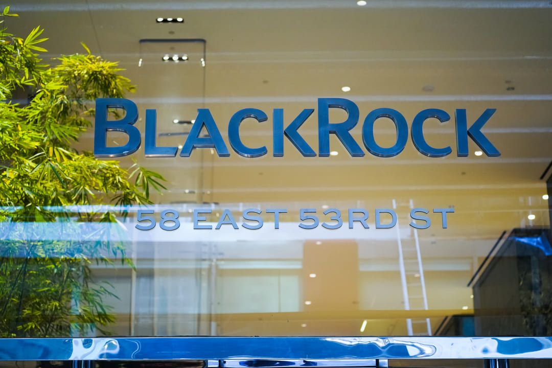 Imagem de escritório da BlackRock, empresa fundada por Larry Fink, com letreiro azul em parede de vidro